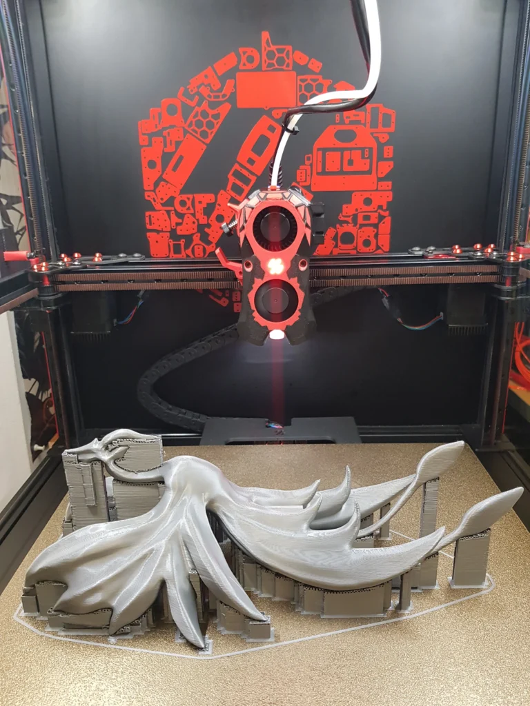 Phoenix sculpture printed in grey on the Voron 2.4, still on its supports